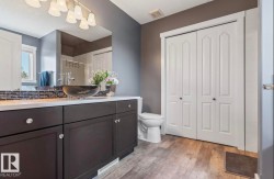 Vanity featuring a vessel sink, dark wood-finish cabinetry, and a light-colored countertop - 
