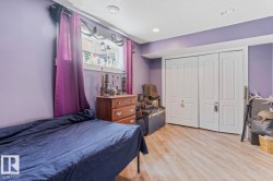 Room featuring light-toned wood-finish flooring, recessed ceiling lighting, and a window with white louvered blinds - 