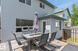 Rear exterior featuring horizontal siding, multiple windows, a ground-level deck, and a wood fence - 