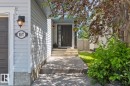 Inviting entryway featuring a dark paneled door, concrete steps, and a concrete pathway - 1007 Macewan Cl, Edmonton, AB 