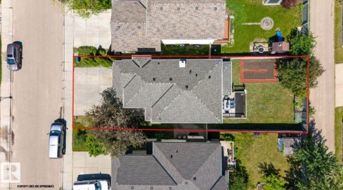 Single-story residence with a gray shingle roof, featuring a paved driveway and a spacious backyard - 1007 Macewan Cl, Edmonton, AB 