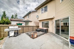 Spacious concrete patio with full privacy fencing and a raised deck area - 