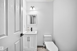 Compact powder room with a white panel door and black hardware - 