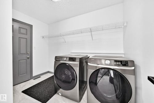 Dedicated laundry area featuring wire shelving, white walls, and light-toned flooring - 1549 37C Avenue, Edmonton, AB 
