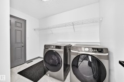Dedicated laundry area featuring wire shelving, white walls, and light-toned flooring - 