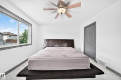Bright room featuring a wide window with dark grey trim, white walls, and light-toned flooring - 