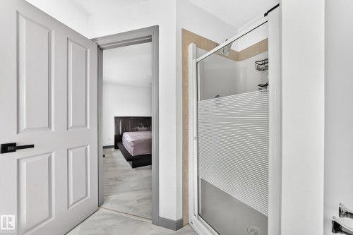 Modern shower enclosure with frosted glass panel and integrated shelving - 1549 37C Avenue, Edmonton, AB 