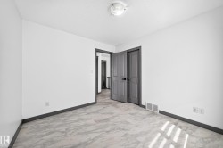 Tile flooring with a marble-effect pattern, contrasting dark baseboards, and a neutral white wall color - 