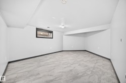 Spacious interior featuring light gray walls, dark trim, and patterned flooring - 