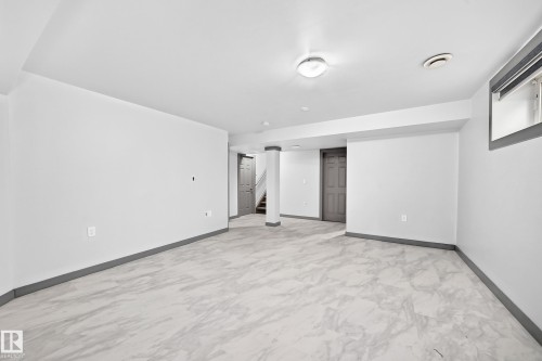 Spacious room featuring light-toned large format tile flooring and a neutral color palette - 1549 37C Avenue, Edmonton, AB 
