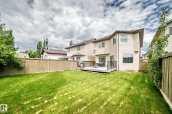 Expansive green lawn with a wood fence enclosure - 