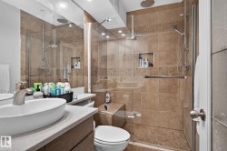 Tiled shower enclosure featuring a glass door, rainfall showerhead, and integrated bench seating - 
