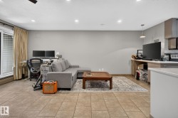 Open-concept living area featuring tile flooring, recessed lighting, and a sliding glass door with vertical blinds - 