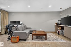 Spacious room featuring tile flooring, light gray walls, recessed lighting, a window with vertical blinds and drapes, and a built-in media cabinet - 