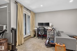 Spacious room featuring tile flooring, light gray walls, recessed lighting, and a sliding glass door with a transom window - 