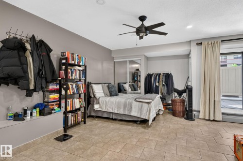 Spacious room featuring neutral-toned tile flooring, recessed lighting, and a ceiling fan - G14 10148 118 Street Nw, Edmonton, AB 