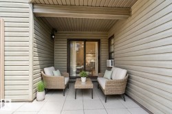 Patio featuring light-toned concrete pavers and horizontal siding - 