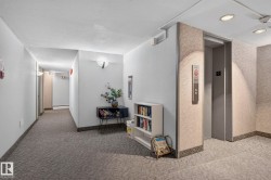Elevator access in a hallway featuring textured wall coverings and patterned carpet flooring - 