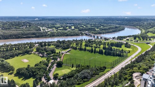 Expansive aerial perspective showcasing a wide river, lush green parklands, a multi-lane roadway, a prominent bridge, and densely wooded areas - G14 10148 118 Street Nw, Edmonton, AB 