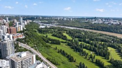 Aerial perspective showcasing a city skyline, a broad river, and extensive green spaces - 