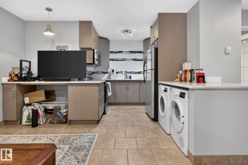 Kitchen featuring light wood-finish cabinetry, stainless steel appliances, and a subway tile backsplash - G14 10148 118 Street Nw, Edmonton, AB 