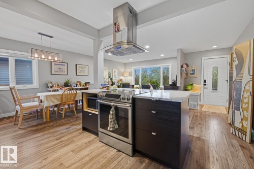 Kitchen island with quartz countertop, stainless steel range and overhead hood fan - 10328 73 Street, Edmonton, AB 