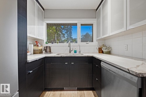Kitchen featuring stainless steel appliances and quartz countertop - 10328 73 Street, Edmonton, AB 