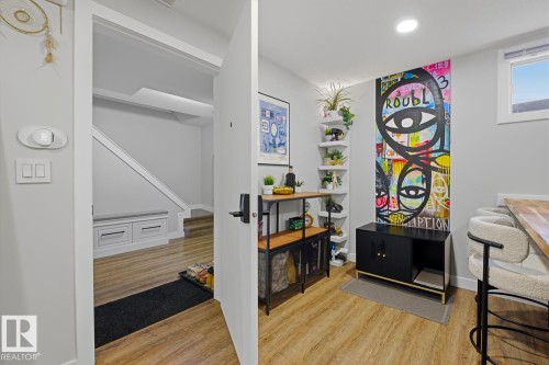 Spacious basement common landing area and suite entrance featuring vinyl plank flooring and LED lighting throughout - 10328 73 Street, Edmonton, AB 