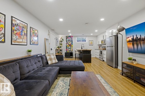 Open-concept living space featuring recessed LED lighting and vinyl plank flooring throughout - 10328 73 Street, Edmonton, AB 