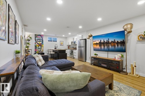 Open-concept living space featuring recessed LED lighting and vinyl plank flooring throughout - 10328 73 Street, Edmonton, AB 
