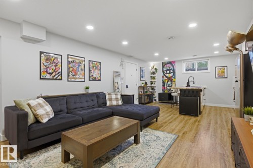 Open-concept living space featuring recessed LED lighting and vinyl plank flooring throughout - 10328 73 Street, Edmonton, AB 
