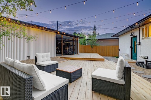 Expansive multi-level wooden deck providing ample outdoor living space, surrounded by low maintenance landscaping and a fully fenced, secured back yard - 10328 73 Street, Edmonton, AB 