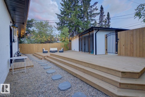Expansive multi-level wooden deck providing ample outdoor living space, surrounded by low maintenance landscaping and a fully fenced, secured back yard - 10328 73 Street, Edmonton, AB 