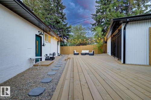 Expansive multi-level wooden deck providing ample outdoor living space, surrounded by low maintenance landscaping and a fully fenced, secured back yard - 10328 73 Street, Edmonton, AB 