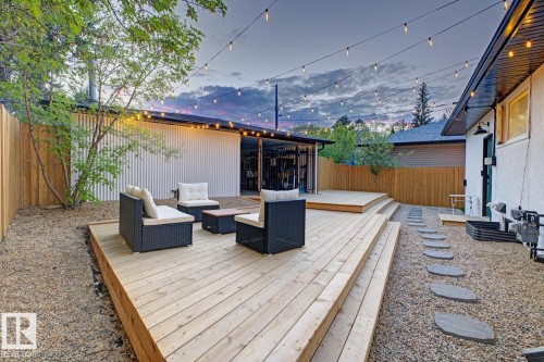 Expansive multi-level wooden deck providing ample outdoor living space, surrounded by low maintenance landscaping and a fully fenced, secured back yard - 10328 73 Street, Edmonton, AB 