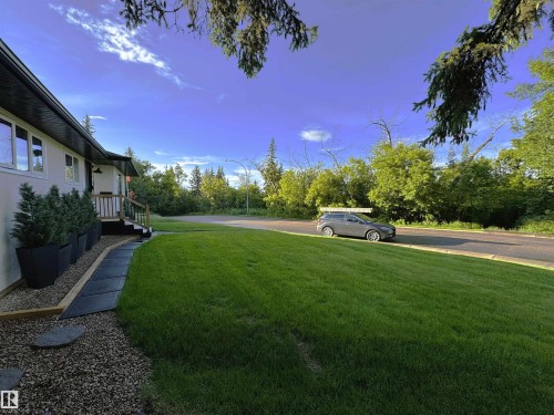 Boasting a lush front lawn, the property is directly across from Fulton Ravine, providing gorgeous year-round views from both inside and out of the home - 10328 73 Street, Edmonton, AB 