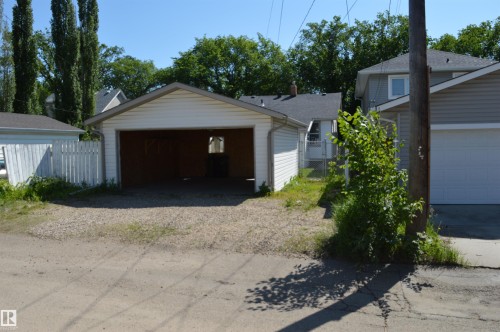 Detached garage with white siding and a gravel parking pad - 11920 78 Street, Edmonton, AB 