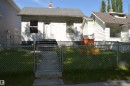 White siding exterior with a grey shingle roof, chimney, and an enclosed front yard - 11920 78 Street, Edmonton, AB 