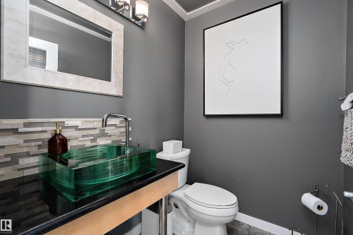 Powder room featuring a translucent green vessel sink with a chrome faucet - 4 Wentworth Crescent, St. Albert, AB 