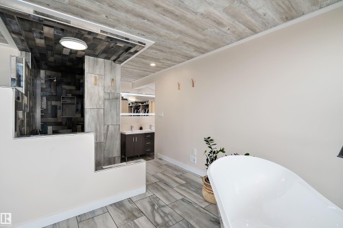 Contemporary bathroom featuring a freestanding soaking tub and a dedicated shower area with varied tile finishes - 4 Wentworth Crescent, St. Albert, AB 