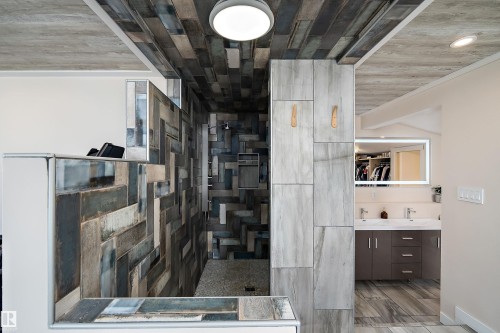 Contemporary walk-in shower featuring patterned wall tiling and a pebble-finish floor - 4 Wentworth Crescent, St. Albert, AB 