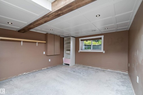 Recessed lighting illuminates the space, featuring a wood-finish ceiling beam and a drop panel ceiling - 4 Wentworth Crescent, St. Albert, AB 