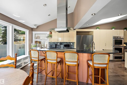 Kitchen featuring a central island with a black countertop and pendant lighting - 4 Wentworth Crescent, St. Albert, AB 