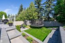 Multi-level backyard featuring a composite deck, stone patio, manicured lawn, and privacy fencing - 4 Wentworth Crescent, St. Albert, AB 