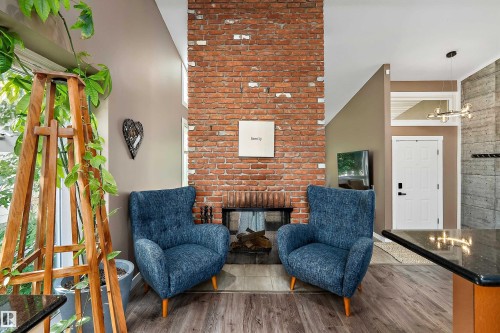 Exposed brick fireplace with a glass front, flanked by two windows - 4 Wentworth Crescent, St. Albert, AB 