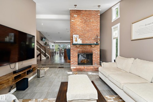 Exposed brick fireplace with a stone hearth, featuring a dark wood mantelpiece - 4 Wentworth Crescent, St. Albert, AB 