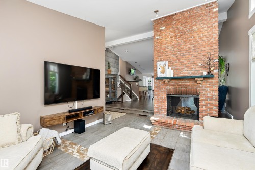 Distinguished brick fireplace with a dark wood mantelpiece - 4 Wentworth Crescent, St. Albert, AB 