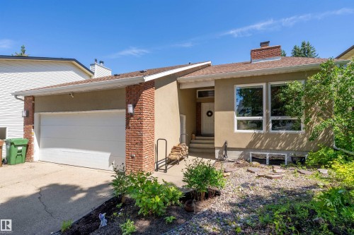Contemporary split-level residence featuring a stucco and brick facade, an integrated garage, and a front entry with stone steps - 4 Wentworth Crescent, St. Albert, AB 