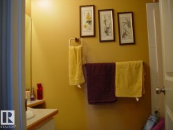 Bathroom featuring a wall-mounted towel rack and vanity with a light-colored countertop - 