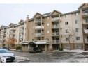 Multi-story residential building featuring a stucco exterior and multiple balconies with white railings - #116 10535 122 St Nw, Edmonton, AB  - Outdoor With Facade 
